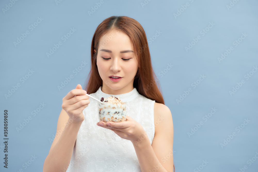Portrait of pretty smiling fit girl having yogurt, raisins and oatmeal. Portrait of pretty smiling fit girl having yogurt, raisins and oatmeal.