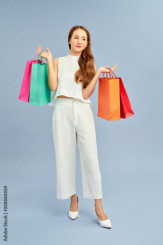 Asian smiling young woman with colorful paper bags. Concept for shop sales.