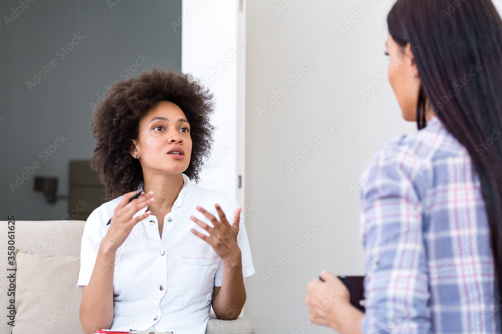 Woman at therapy session. Attentive psychologist. Attentive psychologist holding pencil in her hands making written notes while listening to her client Woman at therapy session. Attentive psychologist. Attentive psychologist holding pencil in her hands making written notes while listening to her client