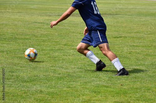 Football, soccer player running with the ball, closeup view of legs