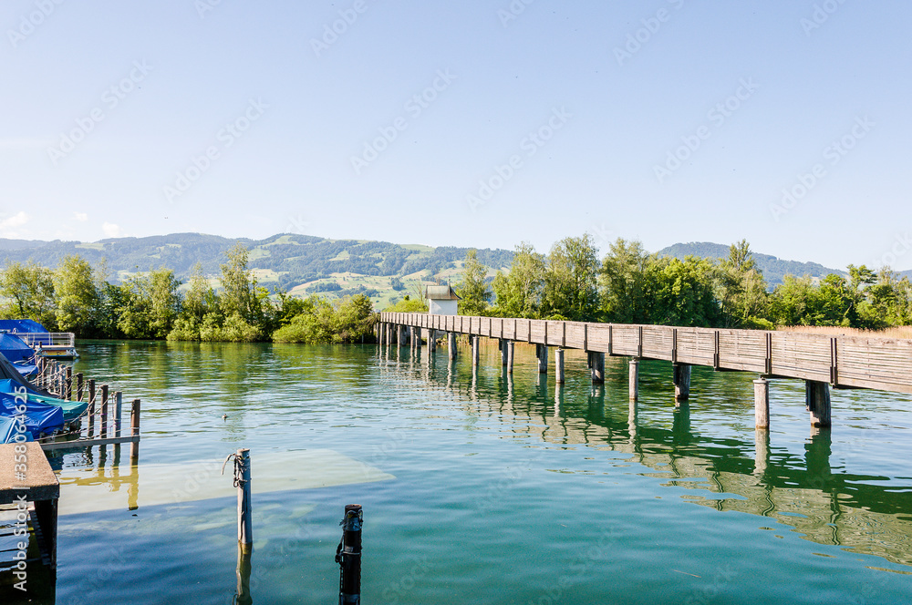 Fototapeta premium Rapperswil, Zürichsee, Holzsteg, Holzbrücke, Wanderweg, Seedamm, See, Boote, Hafen, Naturschutz, Wasservögel, Pfäffikon, Schilf, Schifffahrt, Sommer, Schweiz