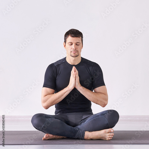 Man yoga class. Black wear. Calm relax pose. Closed eyes. Zen exercise. Male person sitting at mat. Body care intenational day. Hand mudra sign photo