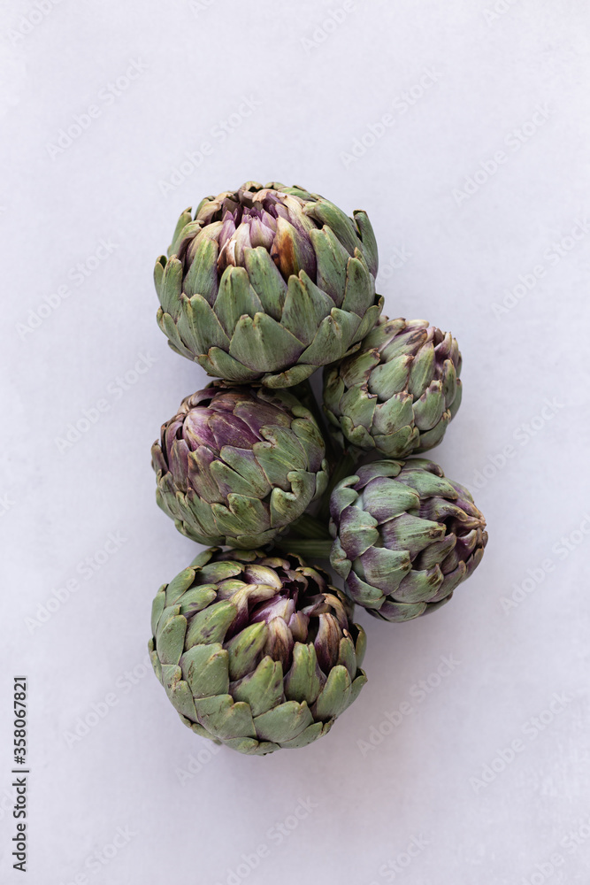 Fototapeta premium Topview image of artichokes on a light gray background.