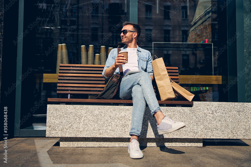 Relaxed man crossing legs while sitting on the bench Stock Photo