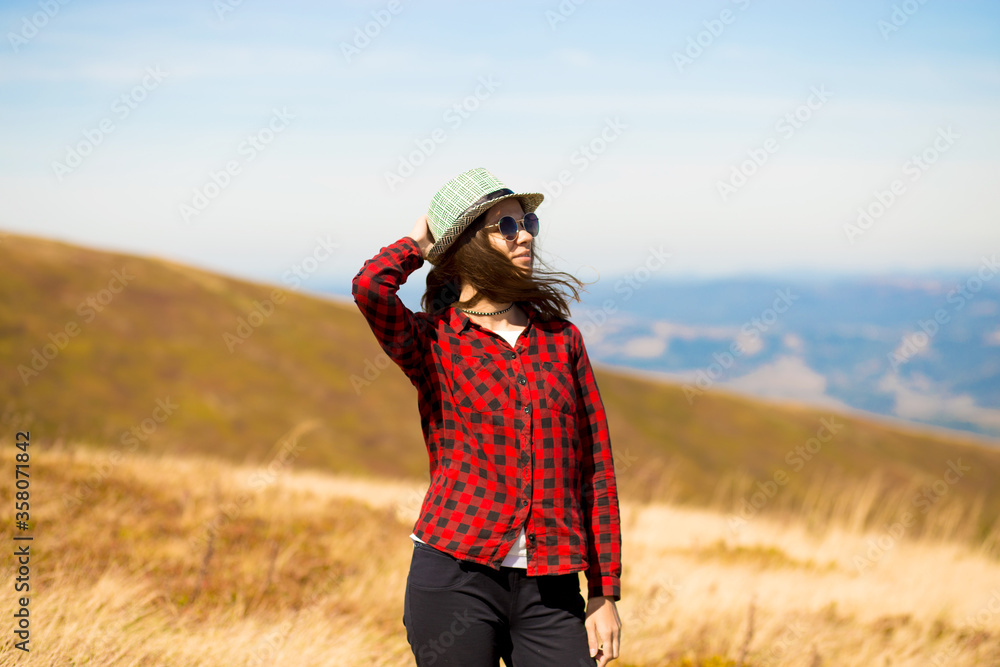 Girl with hat walk with happiness on top of mountain range in autumn.