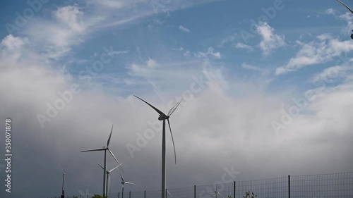 Wallpaper Mural Windmill in the field. Ecological method of energy production. Caring for the world, technology of the future. Cloudy sky and large blades. Cop space. slow motion Torontodigital.ca