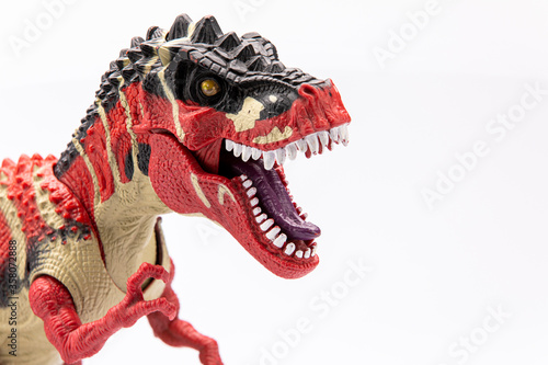 close-up of a colorfull plastic figurine of a tyranosaurus  isolated on a white background