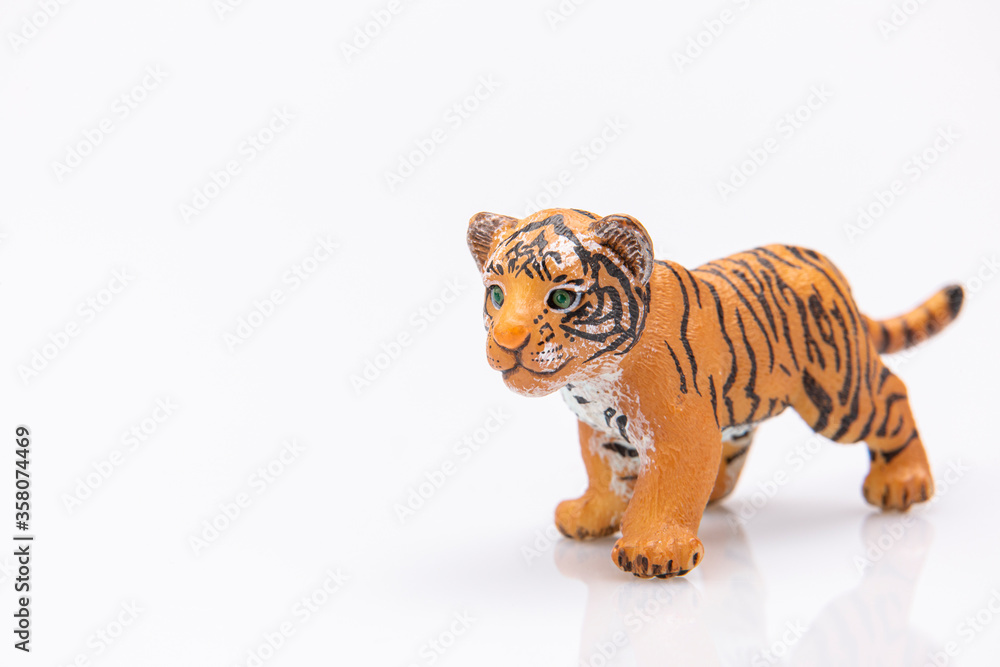 Obraz premium close up of a baby tiger made from plastic isolated on a white background
