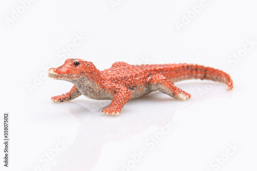 close-up of a orange plastic crocodile isolated on a white background