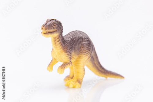 close-up of a colorfull plastic dinosaur figurine isolated on a white background © Xavier Lejeune