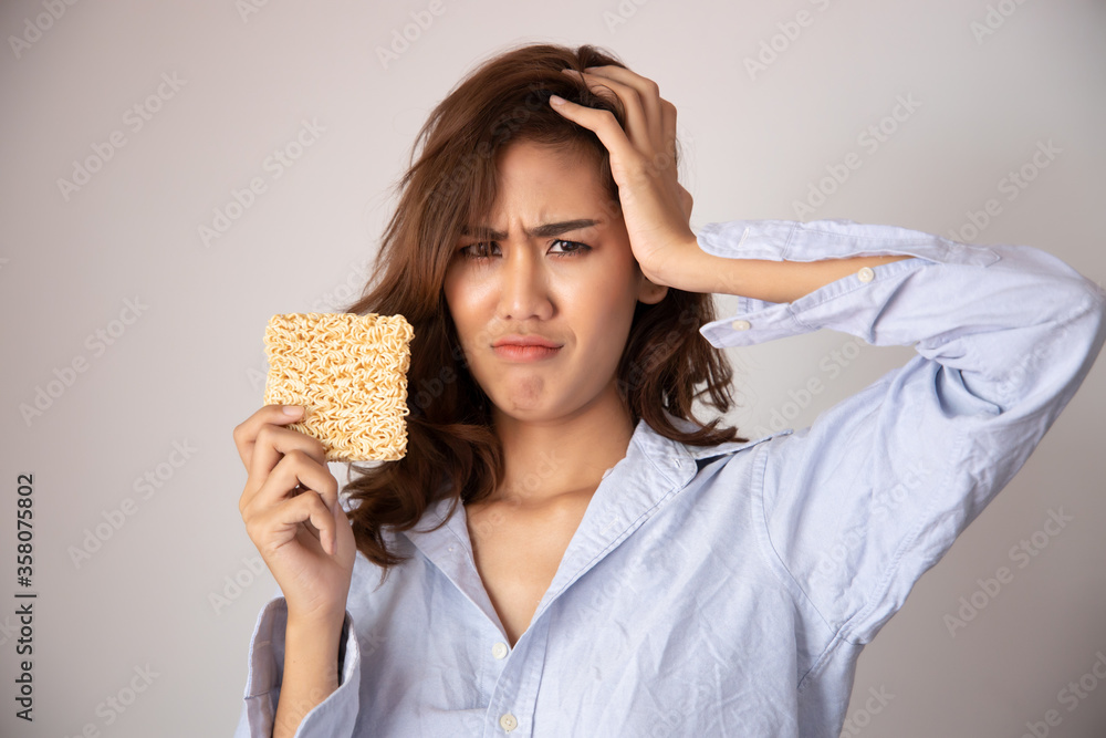 Φωτογραφία unhappy, sad girl having instant noodle, concept of cheap budget fast food for j