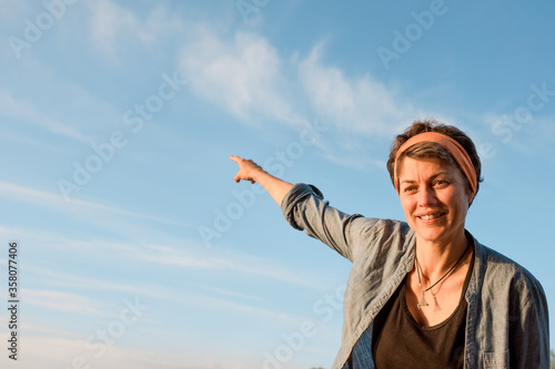 The woman points her finger at the sky