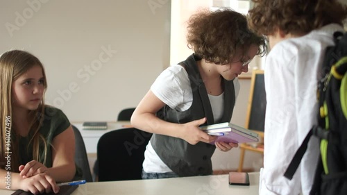 Harassing at school. Boy bully drove a girl classmate from her place at her desk. Moral abuse bullying at school