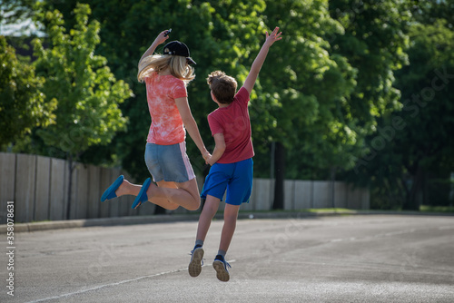 Happy mother and son holding hands while jumping  © Ognian Setchanov