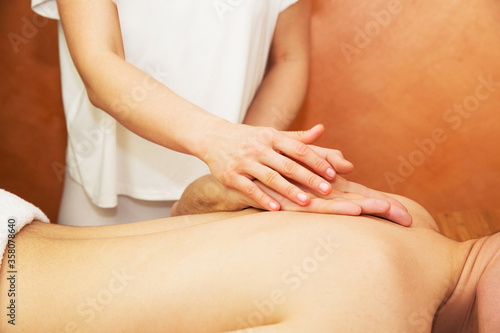 Young man getting massage with masseur
