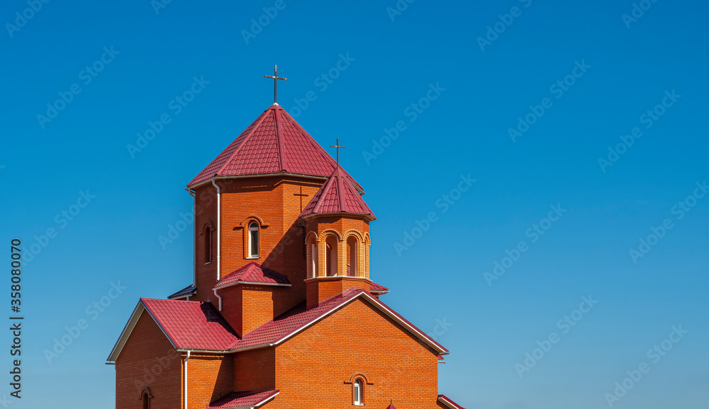 Catholic church with crosses on the towers against a cloudless blue summer sky Catholic church with crosses on the towers against a cloudless blue summer sky