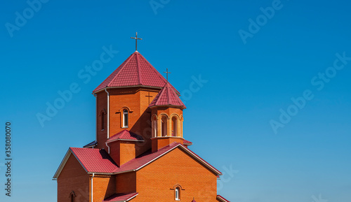 Catholic church with crosses on the towers against a cloudless blue summer sky
