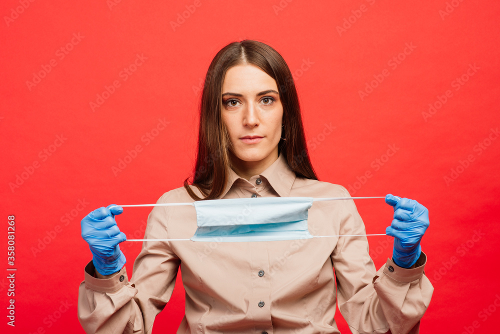 Emotional beautiful businesswoman in medical mask and gloves. Pandemic coronavirus epidemic covid-19 quarantine isolated red Emotional beautiful businesswoman in medical mask and gloves. Pandemic coronavirus epidemic covid-19 quarantine isolated red