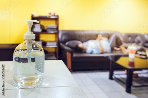 Alcohol gel bottle placed on the counter with a blurred background of the quarantine woman and resting to prevent the spread of the corona virus(Covid-19) at home.Social distancing to protect Covid-19