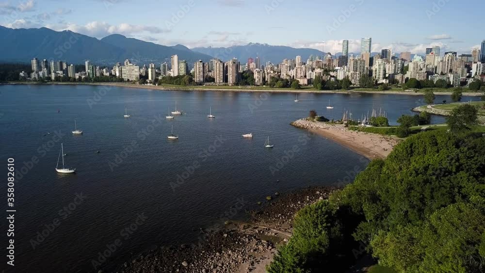 Stunning Landscape Of Downtown Skyline And English Bay Beach From Kitsilano Beach With Sailboats On The Blue Ocean In Vancouver, British Columbia, Canada. - aerial drone Stunning Landscape Of Downtown Skyline And English Bay Beach From Kitsilano Beach With Sailboats On The Blue Ocean In Vancouver, British Columbia, Canada. - aerial drone
