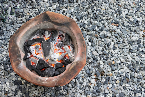 The red fire is burning the coals in the stove and there is a rocky background, taken from the topviw corner. photo