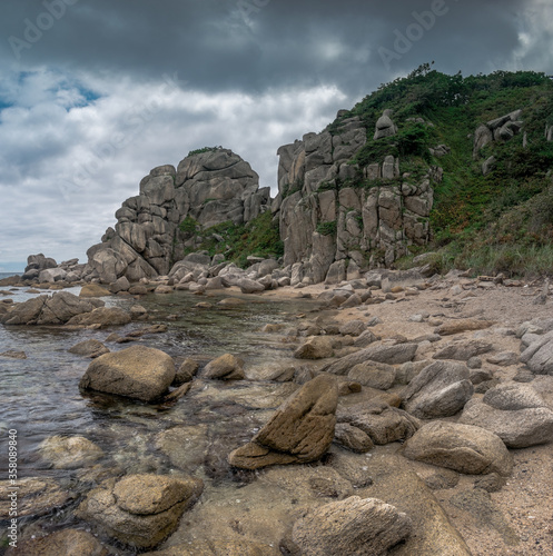 Sea shore with large stones against a cloudy sky