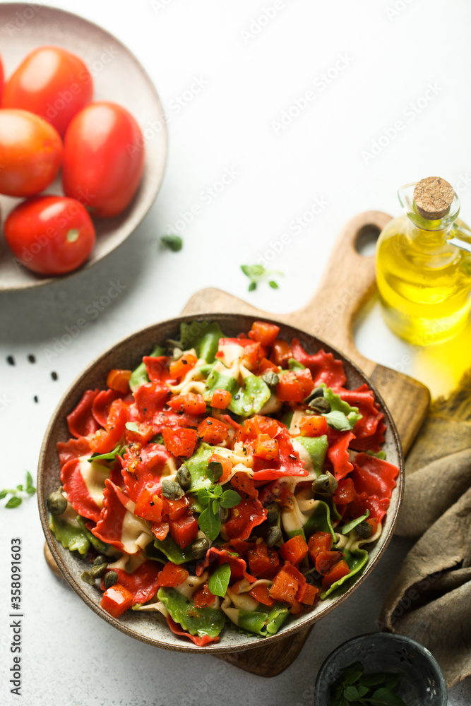 Multi-colored Italian pasta with capers and tomatoes Multi-colored Italian pasta with capers and tomatoes