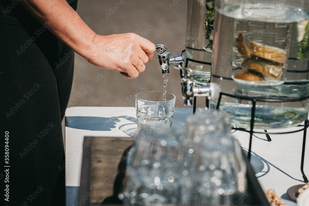 A person tapping water from a small water tap