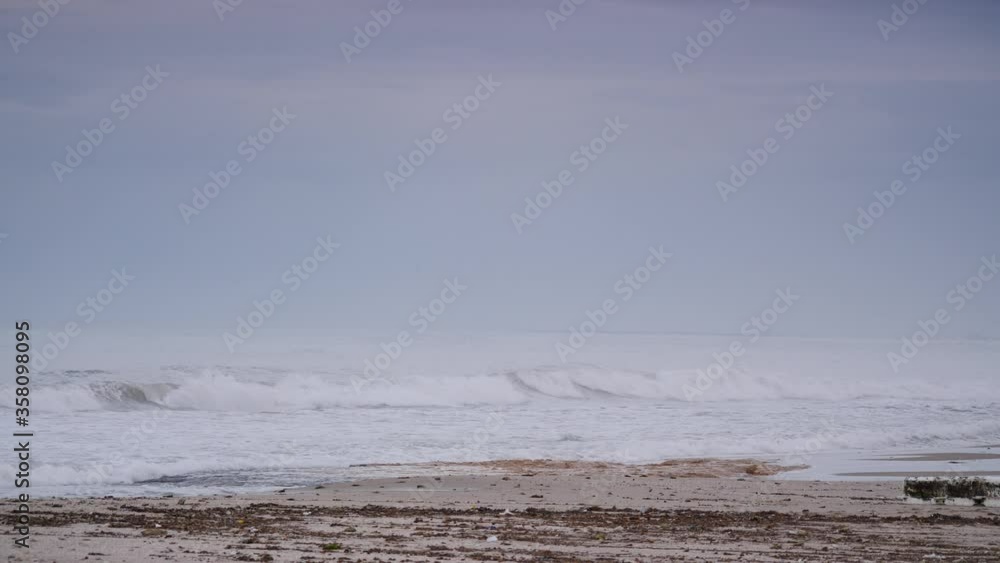 Spanish beach sea waves at cloudy misty weather. Mediterranean Sea landscape, coast in Valencia region, Alicante. Tourist site. Slow motion

