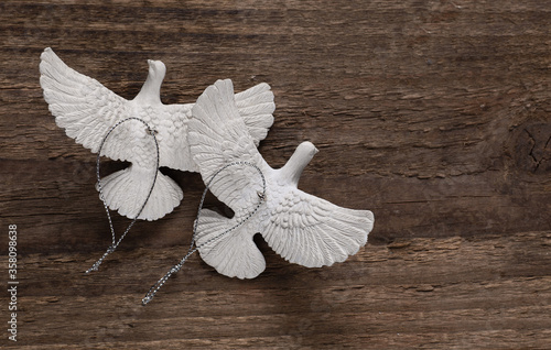 Turtle doves on the wooden board. Each turtle dove is intricately sculptured from an artisan with resin material to look realistic like real doves. 