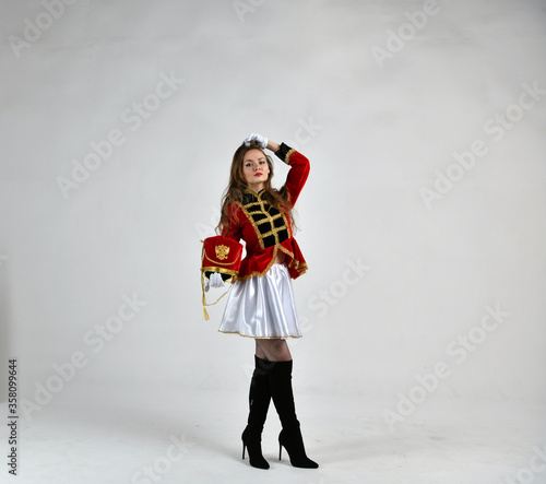 Obraz na płótnie beautiful girl in red hussar uniform marching with a sword