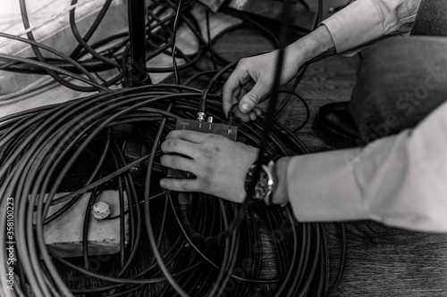 connecting cables to the switch. Black and white. Large mechanic hand image.