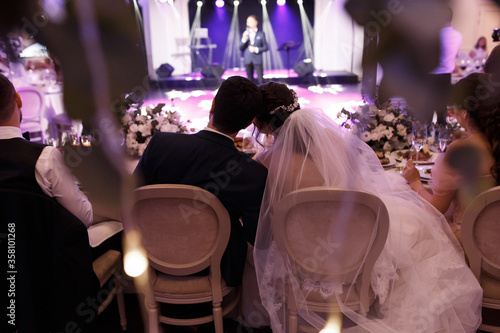 Принти на полотні the couple is sitting at the wedding table embracing