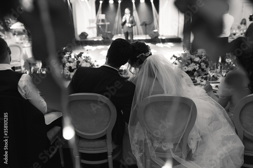 Billede på lærred the couple is sitting at the wedding table embracing