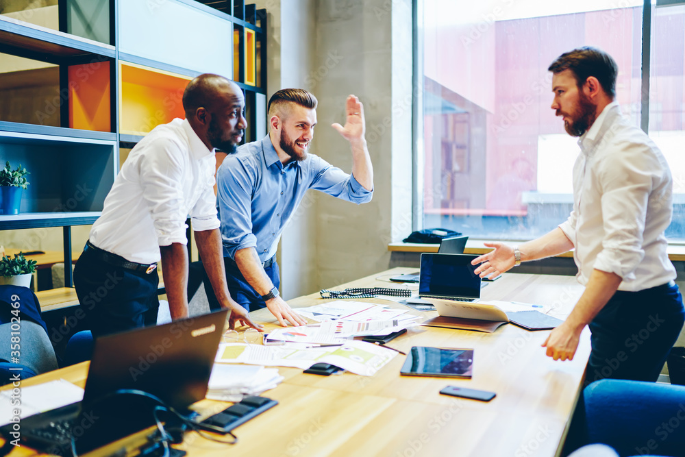Happy office worker celebrating success of project with partners in office Happy office worker celebrating success of project with partners in office