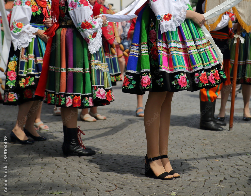 woman in traditional folk clothes costumes from Lowicz region in Poland while join Corpus Christi procession