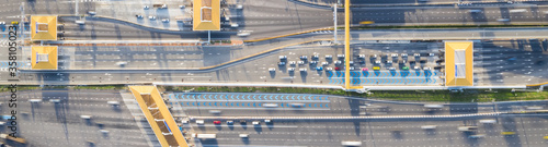 Car traffic transportation on multiple lanes highway road and toll collection gate, drone aerial top view. Commuter transport, city life concept. Banner size