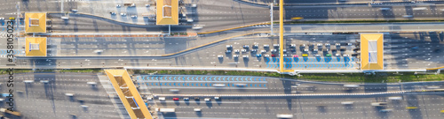 Car traffic transportation on multiple lanes highway road and toll collection gate, drone aerial top view. Commuter transport, city life concept. Banner size photo