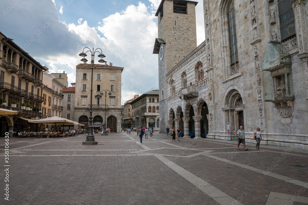 Walking on narrow street in Como city with historic buildings and shops