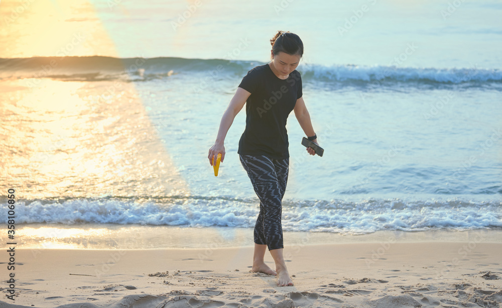 Asian woman walking on beach coastline and sea with social distancing Asian woman walking on beach coastline and sea with social distancing