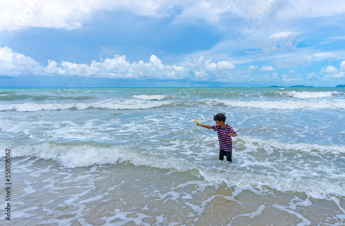 Asian kid enjoy playing in the sea