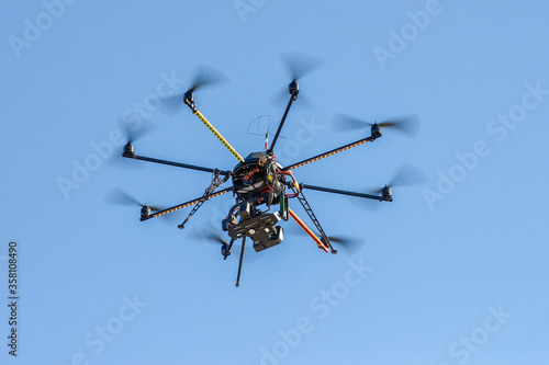 industrial drone with a video camera on a background of blue sky