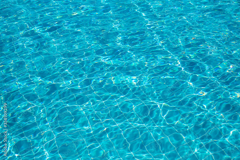 Background of rippled pattern of clean water in a blue swimming pool.