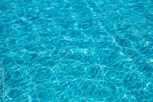 Background of rippled pattern of clean water in a blue swimming pool.