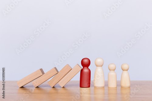 Tablou pe pânză Red wooden figurines representing father stopping the domino effect