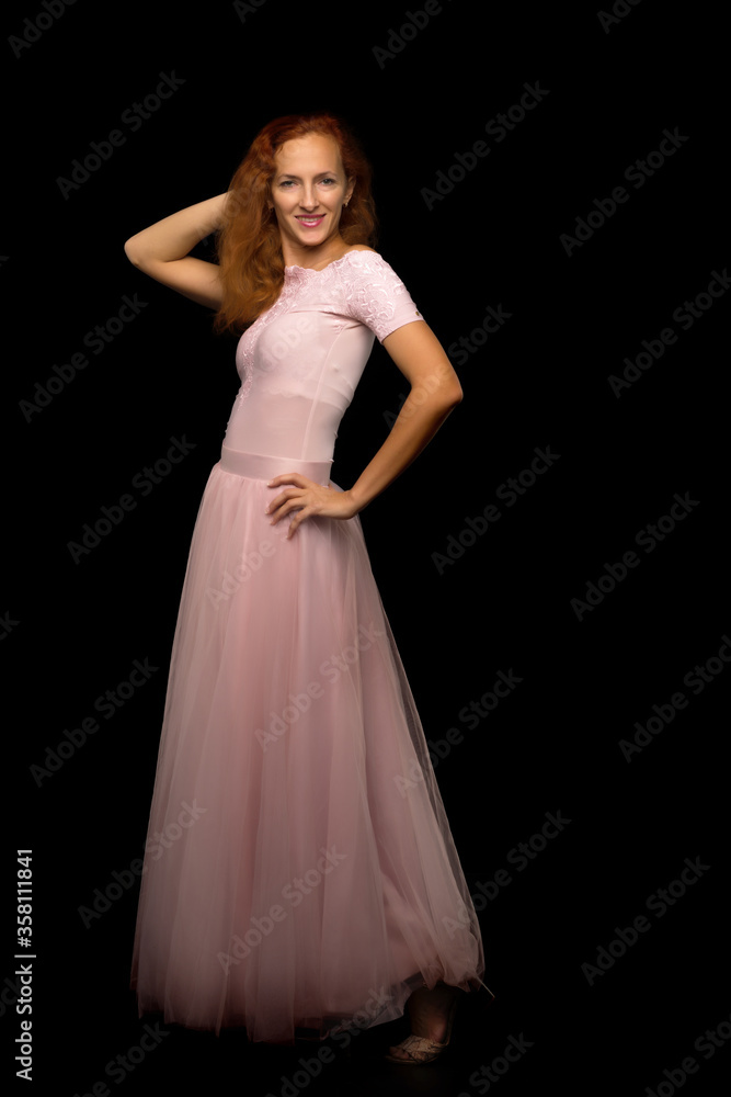 Red-haired young woman in the studio on a black background. Red-haired young woman in the studio on a black background.