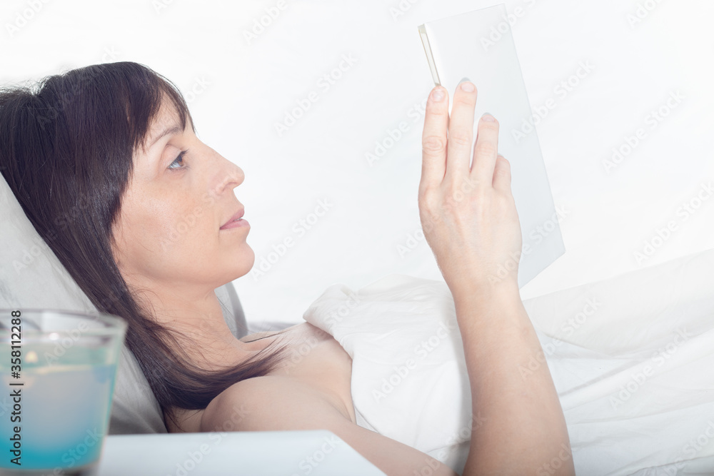 Mujer leyendo un libro en la cama Mujer leyendo un libro en la cama