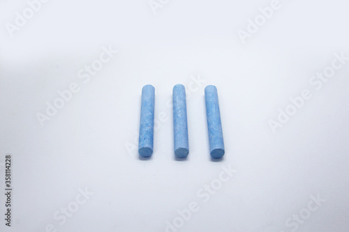 Colored chalk, in the form of small elongated cylinders in a wide variety of colors, used as school supplies for writing or drawing on a blackboard.