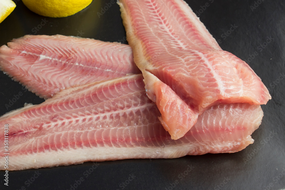 Fresh, unroasted African catfish fillet. Black background Fresh, unroasted African catfish fillet. Black background