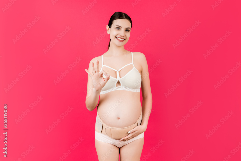 Portrait of pregnant woman in underwear on the third trimester wearing